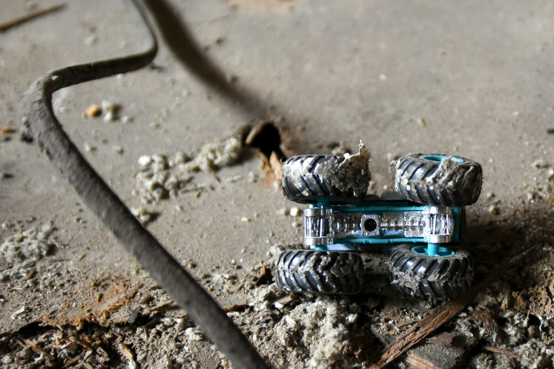 An overturned toy car rests among the rubble